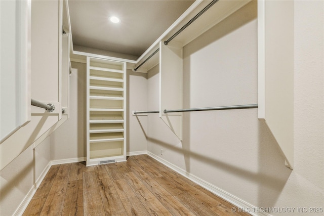 walk in closet featuring wood-type flooring and visible vents
