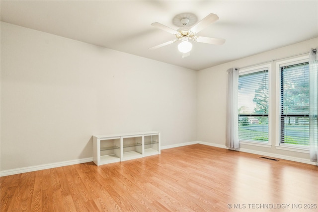 spare room with ceiling fan, baseboards, wood finished floors, and visible vents