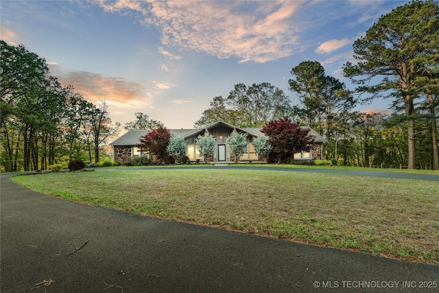 view of front of property featuring a yard and stone siding