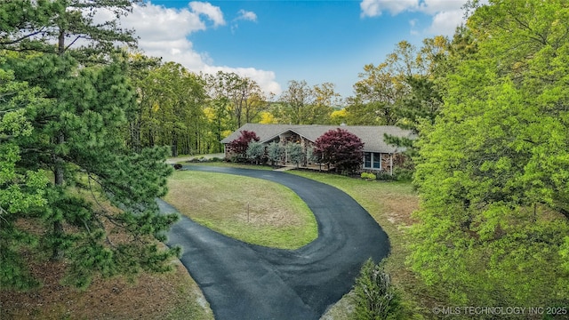 exterior space with a yard and aphalt driveway