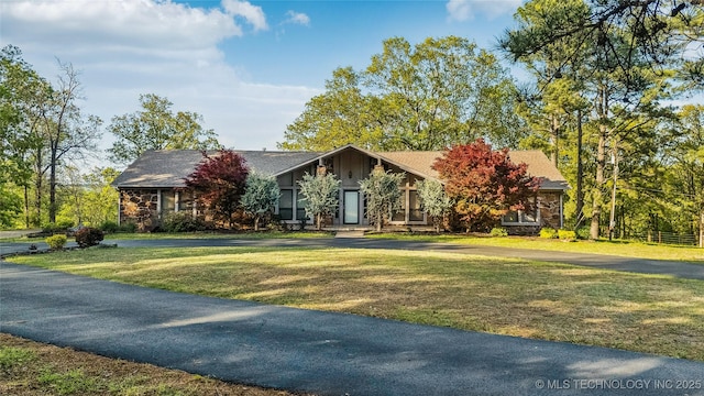 view of front of property featuring stone siding and a front yard