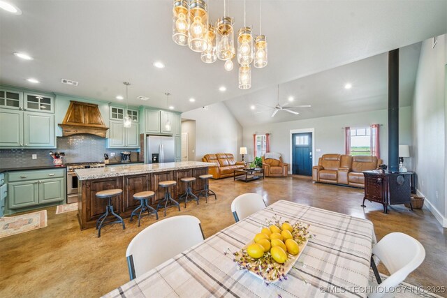 9153 S 4270th Rd, Chelsea, OK 74016 - dining space featuring ceiling fan with notable chandelier, a wood stove, lofted ceiling, visible vents, and recessed lighting