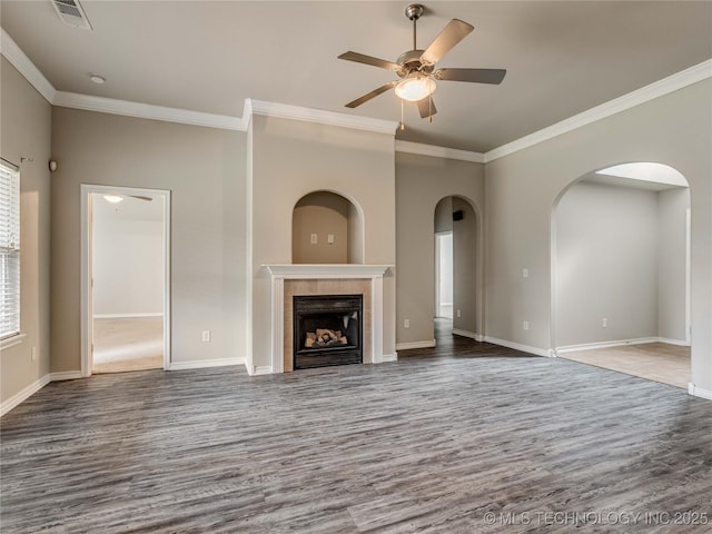 12520 S Birch Ave, Jenks, OK 74037 - unfurnished living room featuring wood finished floors, ceiling fan, ornamental molding, a tiled fireplace, and arched walkways