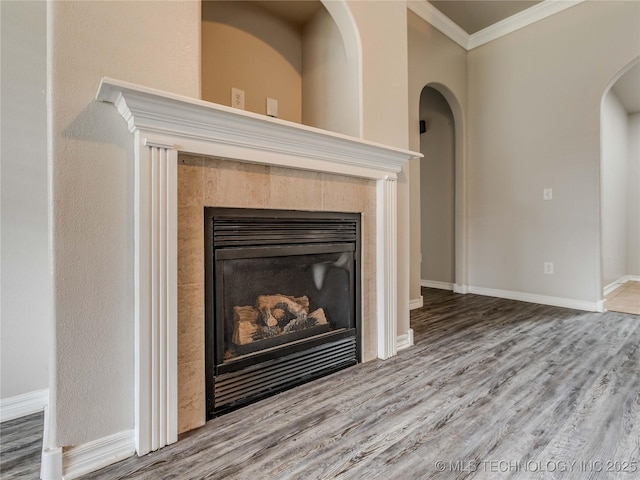 12520 S Birch Ave, Jenks, OK 74037 - detailed view of a tiled fireplace, wood finished floors, crown molding, and arched walkways