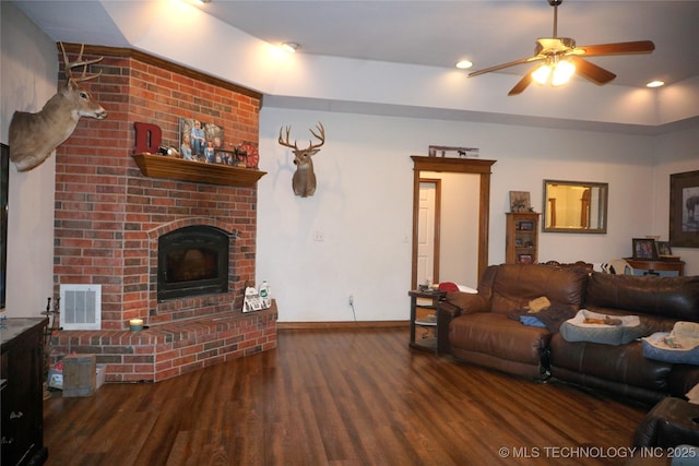 living room with visible vents, baseboards, a brick fireplace, wood finished floors, and ceiling fan