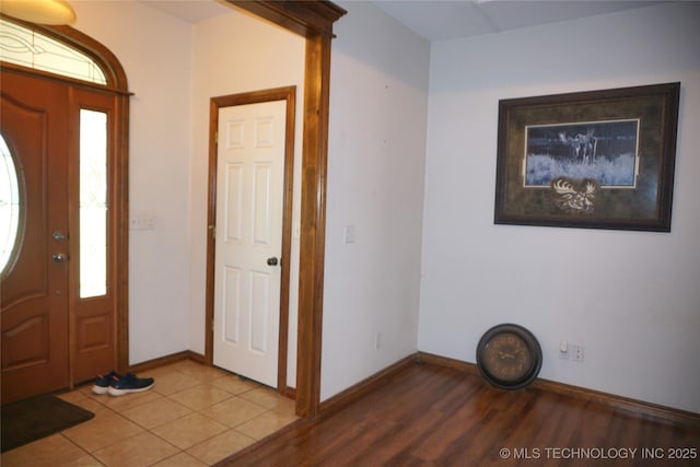 foyer entrance with plenty of natural light, wood finished floors, and baseboards