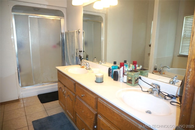 full bath with tile patterned floors, a sink, and a shower stall