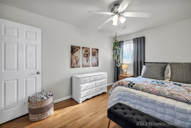 bedroom with ceiling fan, baseboards, and light wood-style floors