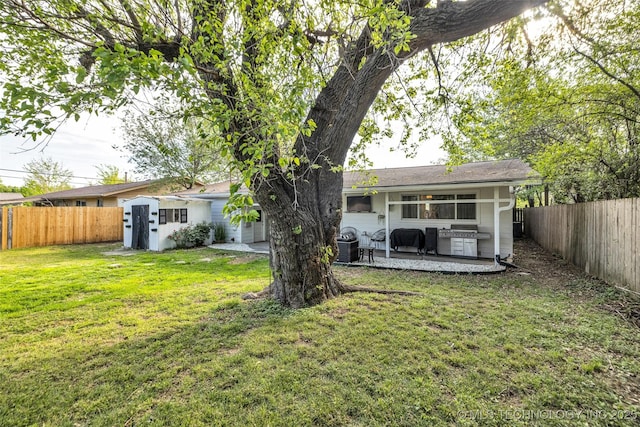 back of property featuring a fenced backyard, a yard, and a patio area