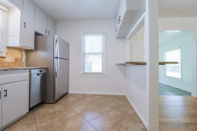 4335 S Cincinnati Ave, Tulsa, OK 74105 - kitchen featuring decorative backsplash, dishwasher, white cabinetry, and light tile patterned flooring
