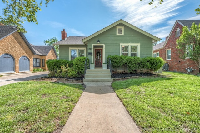 bungalow-style home featuring a chimney and a front yard