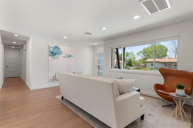 living room with light wood finished floors, baseboards, visible vents, and recessed lighting