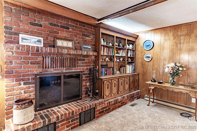 2445 E 156th St N, Skiatook, OK 74070 - living area featuring wood walls, visible vents, carpet floors, a textured ceiling, and baseboard heating