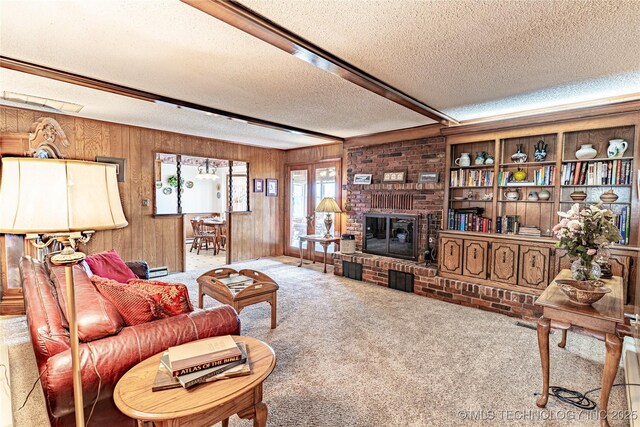 2445 E 156th St N, Skiatook, OK 74070 - carpeted living area featuring beam ceiling, a textured ceiling, wooden walls, and a fireplace