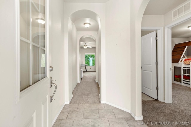 7201 S Joshua Ave, Broken Arrow, OK 74011 - hallway with light tile patterned floors, arched walkways, light colored carpet, baseboards, and visible vents