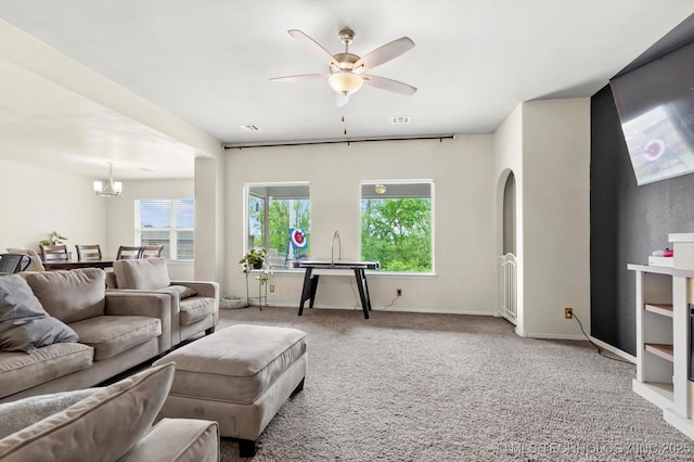 7201 S Joshua Ave, Broken Arrow, OK 74011 - carpeted living room with arched walkways, baseboards, visible vents, and ceiling fan with notable chandelier