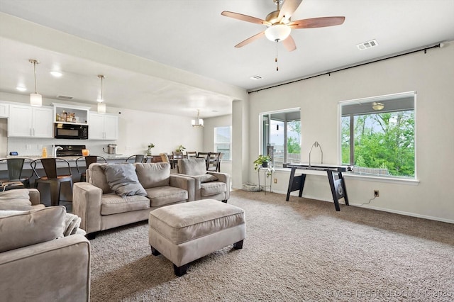 7201 S Joshua Ave, Broken Arrow, OK 74011 - living area with ceiling fan with notable chandelier, baseboards, visible vents, and light colored carpet