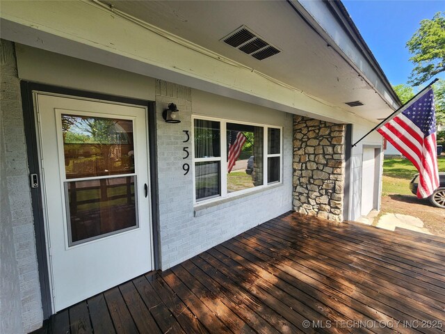 wooden deck featuring visible vents
