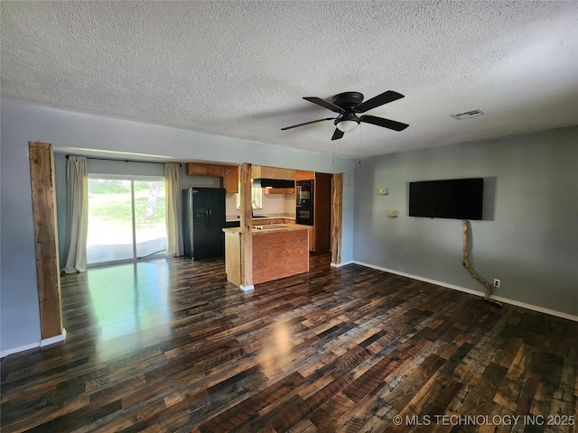 unfurnished living room with ceiling fan, a textured ceiling, baseboards, and dark wood-style flooring