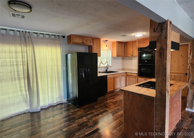kitchen with visible vents, a sink, black appliances, a textured ceiling, and dark wood-style flooring