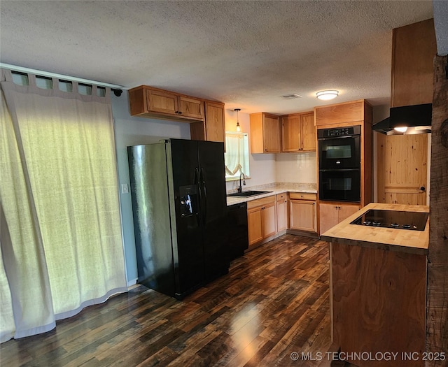 kitchen with black appliances, a sink, dark wood-style floors, and a textured ceiling