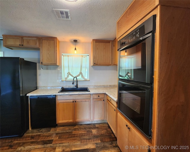 kitchen featuring visible vents, a sink, black appliances, a textured ceiling, and dark wood-style flooring