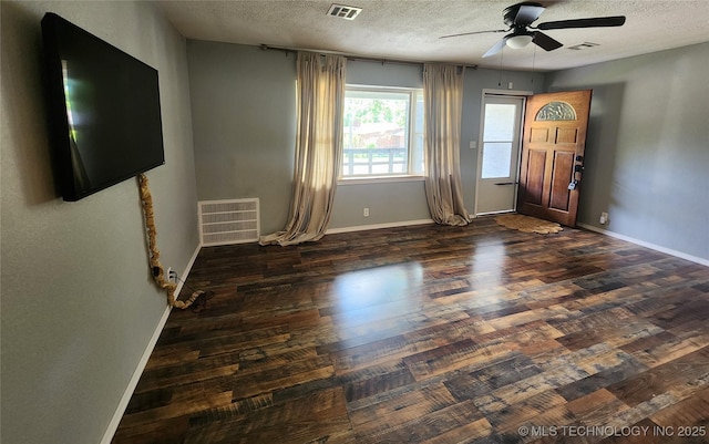 foyer entrance with baseboards, a ceiling fan, visible vents, and a textured ceiling