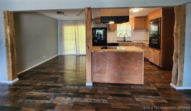 kitchen featuring dark wood-style floors, under cabinet range hood, butcher block counters, baseboards, and black appliances