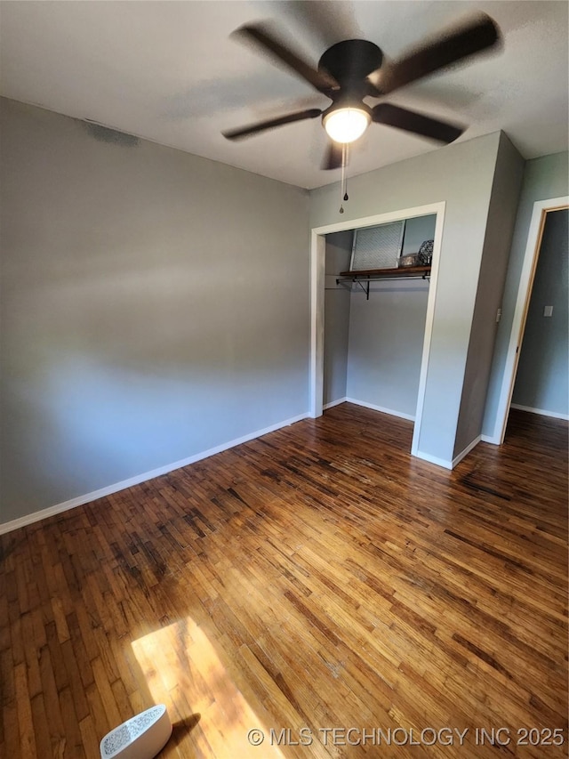 unfurnished bedroom with baseboards, a ceiling fan, wood finished floors, and a closet