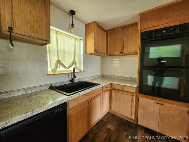kitchen with a sink, decorative light fixtures, black appliances, tasteful backsplash, and dark wood-style flooring
