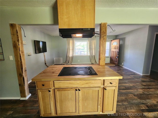 kitchen featuring dark wood-style flooring, black electric stovetop, butcher block counters, baseboards, and under cabinet range hood