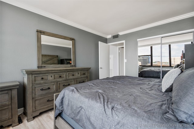 450 W 7th St Unit 1902, Tulsa, OK 74119 - bedroom featuring light wood finished floors, visible vents, crown molding, and baseboards