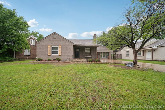 1136 S Evanston Ave, Tulsa, OK 74104 - view of front of home featuring a porch, a chimney, brick siding, and a front lawn