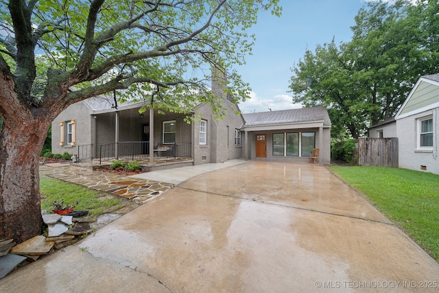 1136 S Evanston Ave, Tulsa, OK 74104 - view of front of house with brick siding, a chimney, and driveway