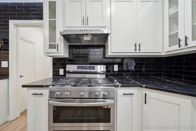 1136 S Evanston Ave, Tulsa, OK 74104 - kitchen with under cabinet range hood, stainless steel range with gas cooktop, dark countertops, and white cabinetry