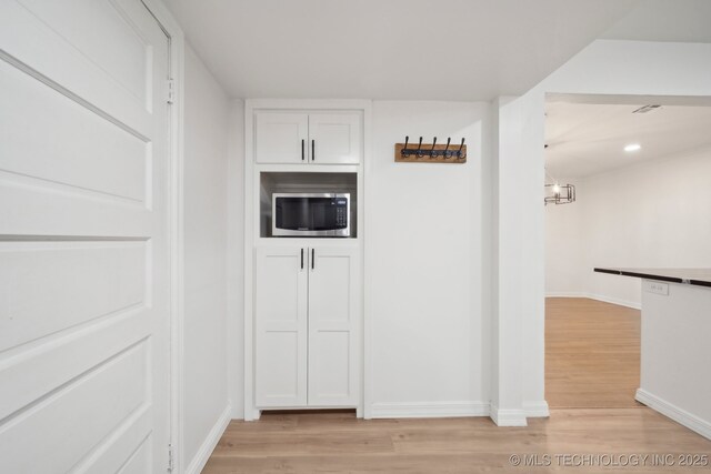1136 S Evanston Ave, Tulsa, OK 74104 - corridor with light wood-type flooring, baseboards, and a chandelier