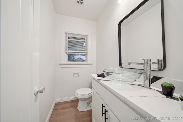 1136 S Evanston Ave, Tulsa, OK 74104 - bathroom featuring baseboards, vanity, wood finished floors, and toilet