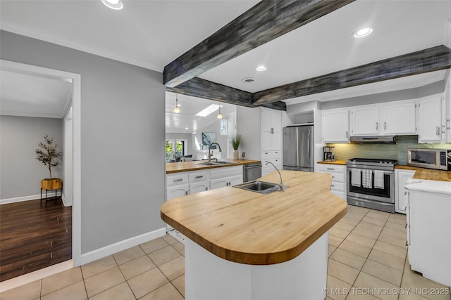 3334 S Wheeling Ave, Tulsa, OK 74105 - kitchen with under cabinet range hood, stainless steel appliances, butcher block countertops, and a sink
