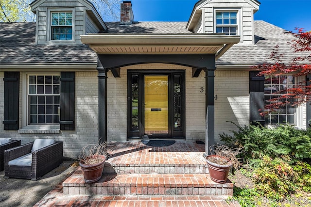 3334 S Wheeling Ave, Tulsa, OK 74105 - property entrance featuring a porch, brick siding, a chimney, and roof with shingles