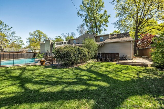 3334 S Wheeling Ave, Tulsa, OK 74105 - rear view of house featuring a lawn, a deck, a fenced in pool, and a fenced backyard