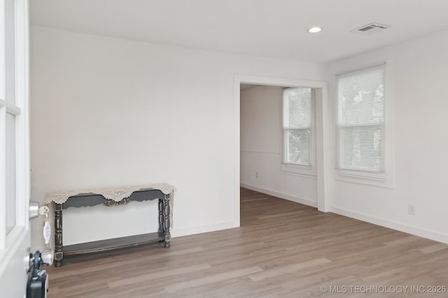 living area featuring baseboards, visible vents, light wood-style flooring, and recessed lighting