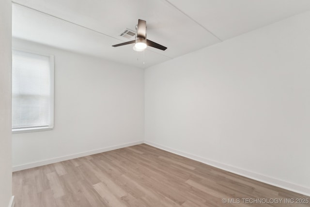 empty room featuring baseboards, visible vents, a ceiling fan, and light wood-style floors