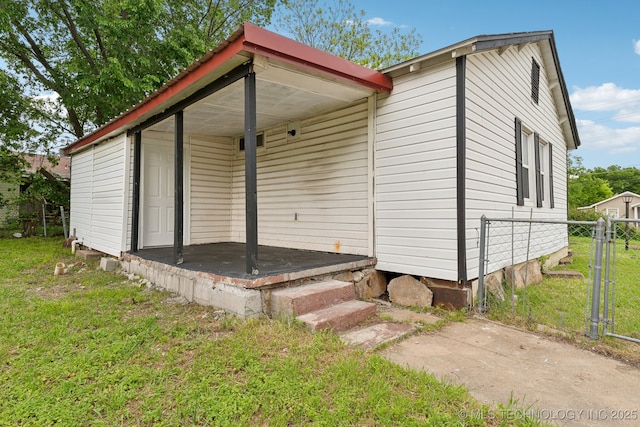 exterior space with a lawn, a gate, and fence