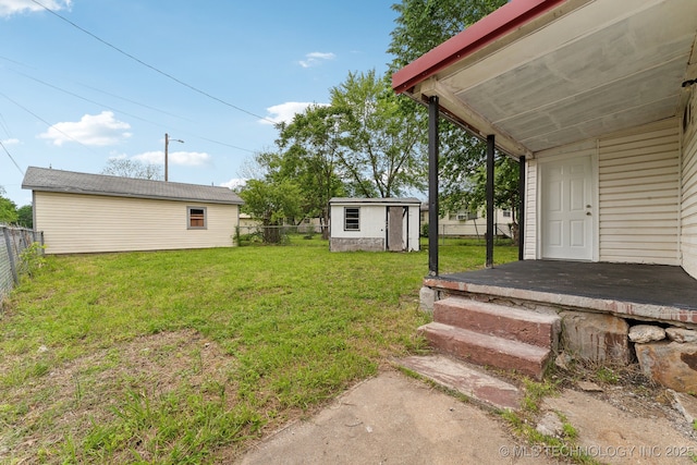 view of yard with a fenced backyard, a shed, and an outbuilding