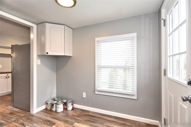 kitchen with freestanding refrigerator, white cabinets, and a healthy amount of sunlight