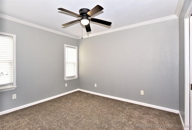 spare room with a ceiling fan, baseboards, ornamental molding, and dark colored carpet
