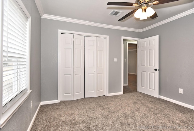 unfurnished bedroom featuring carpet flooring, visible vents, ornamental molding, and a closet