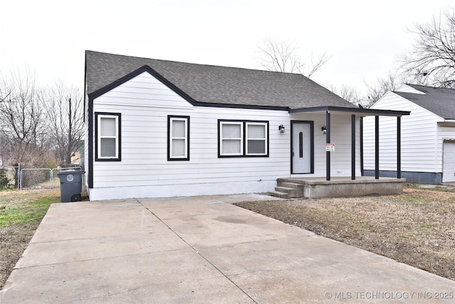 view of front of property featuring a porch, fence, and roof with shingles