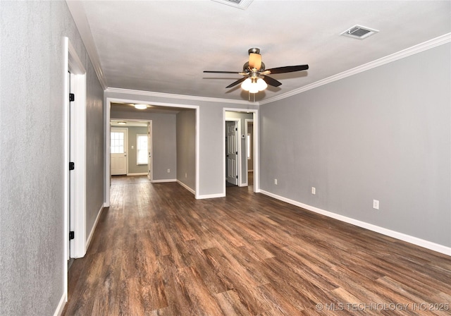unfurnished room with visible vents, ornamental molding, baseboards, ceiling fan, and dark wood-style floors