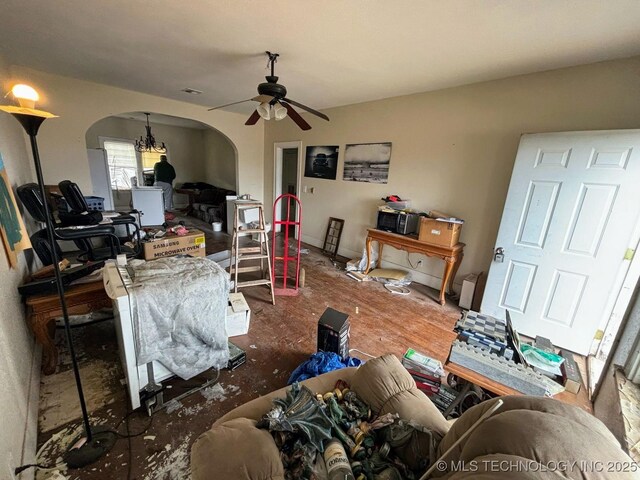 living area featuring a ceiling fan, visible vents, and arched walkways